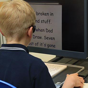 A young boy using a computer to learn about IT and technology.